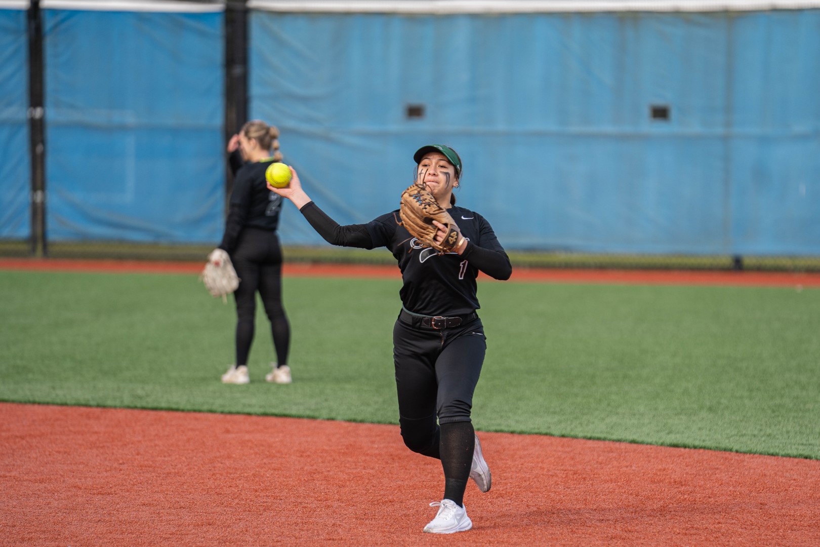 Shoreline softball player fielding and throwing during a game