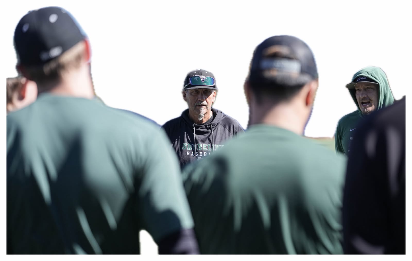 Coach Snell addressing his team in a huddle