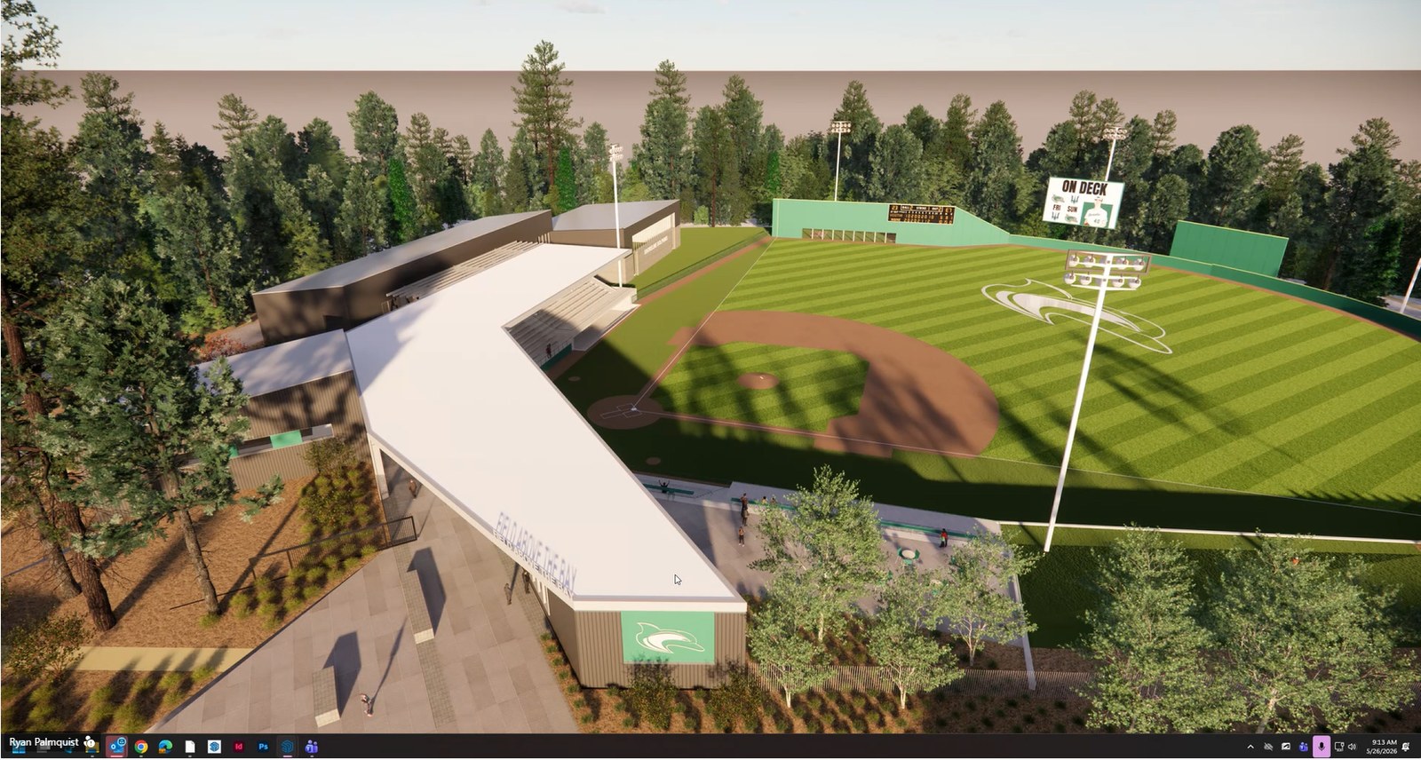 The stadium at twilight with field lights glowing against a pine treeline